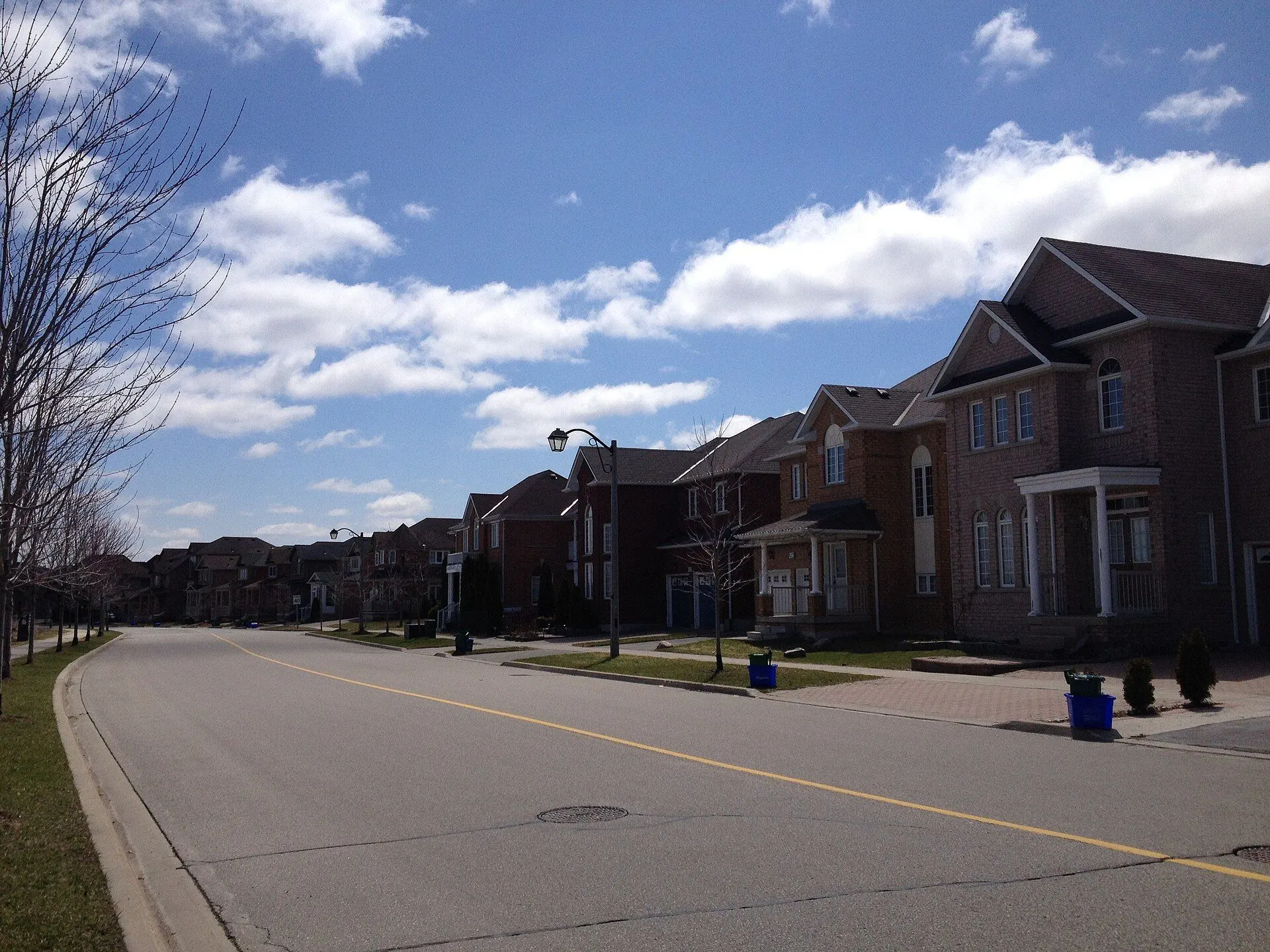 Brick two-storey family homes along a quiet street in Berczy Village, Markham